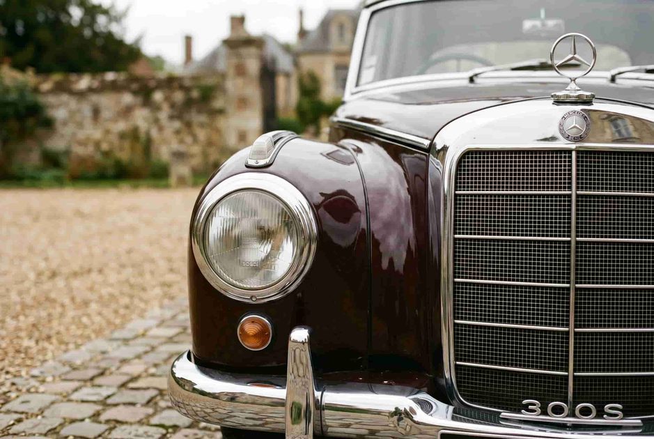 Close detail of 1950s Mercedes-Benz 300S grille and headlamp with modest chrome and small hood star