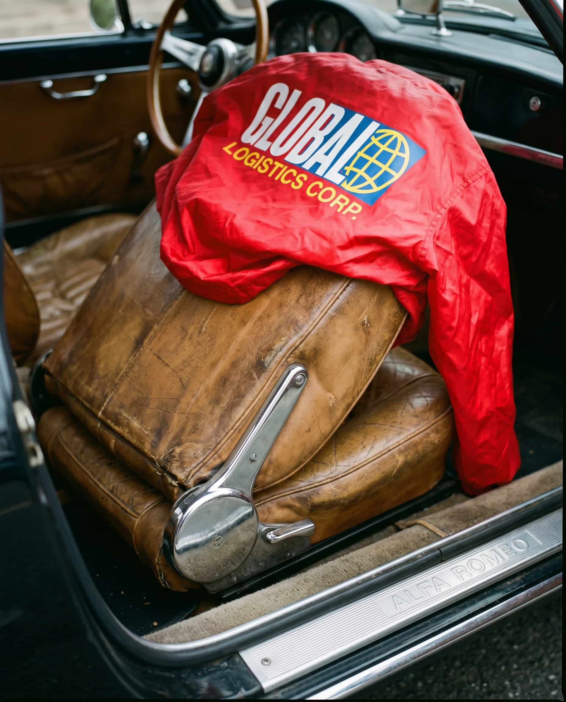 The car's taste vs. the owner's choice Patinated leather driver's seat with cheap windbreaker draped over it, contrast of craftsmanship and fast fashion